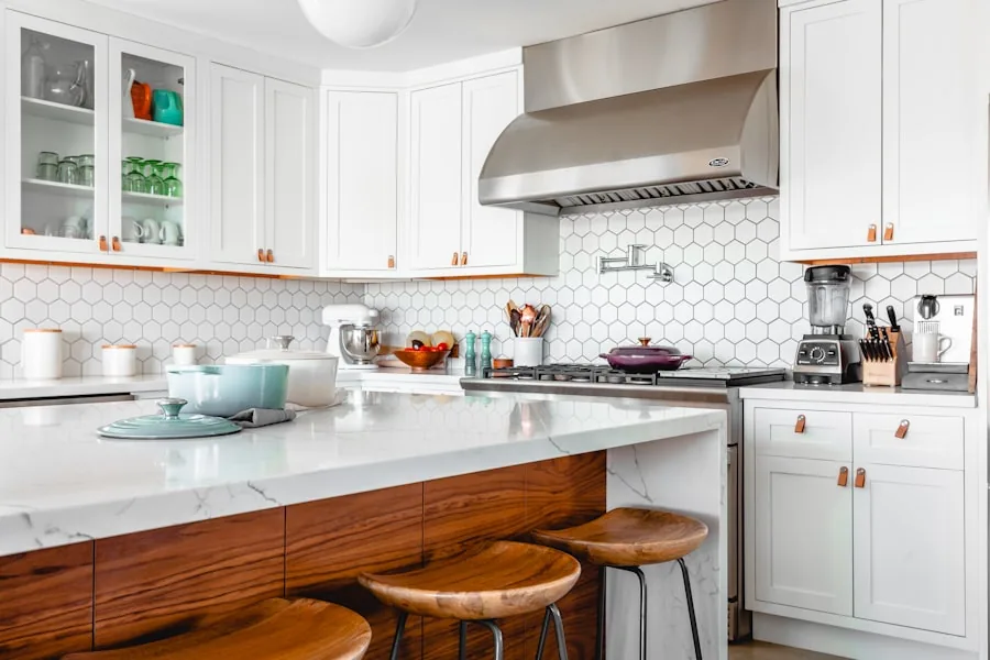 Modern kitchen remodel with white cabinets, wood island, marble countertops, and hex tile backsplash